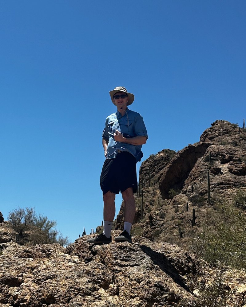 Ryan standing on a rocky outcrop in Saguaro National Park